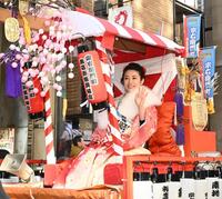 　カゴに乗って手を振るミス宗右衛門町の豊原哉也子さん（撮影・高部洋祐）