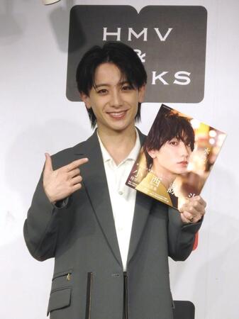 　写真集を手に笑顔の小西詠斗