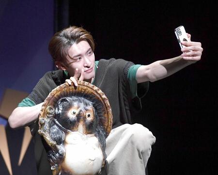 　狸の置物と自撮りをする向井康二