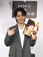 　写真集を手に笑顔の小西詠斗