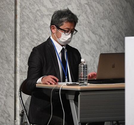 　会見途中、返答に困る経営陣にアドバイスをするスタッフ（撮影・佐々木彰尚）