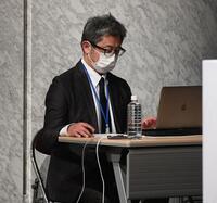 　会見途中、返答に困る経営陣にアドバイスをするスタッフ（撮影・佐々木彰尚）