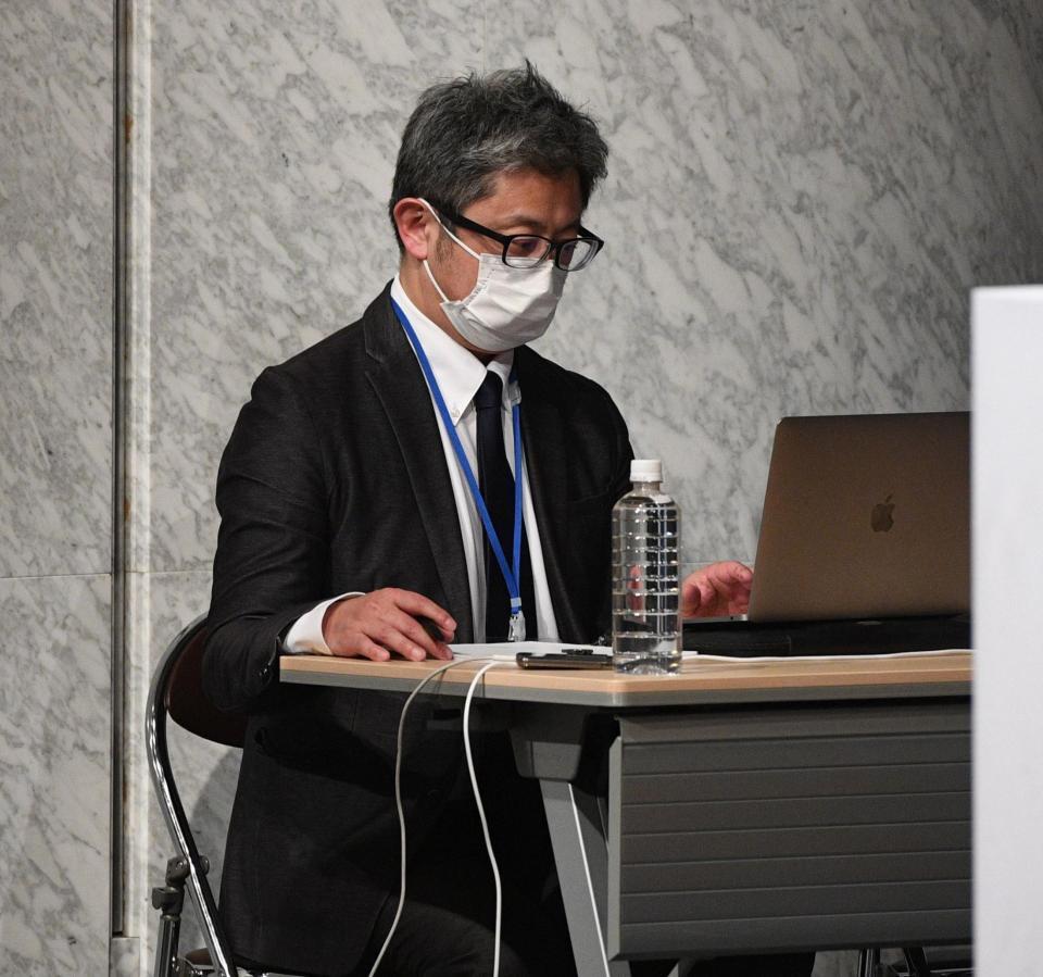 　会見途中、返答に困る経営陣にアドバイスをするスタッフ（撮影・佐々木彰尚）