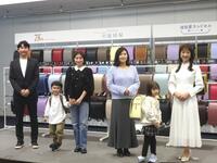 　親子と写真に応じる（一番右の）川田裕美アナウンサー、（一番左の）長岡和久社長