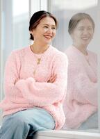 　窓辺で柔和な笑みを浮かべる小泉今日子（撮影・西岡正）