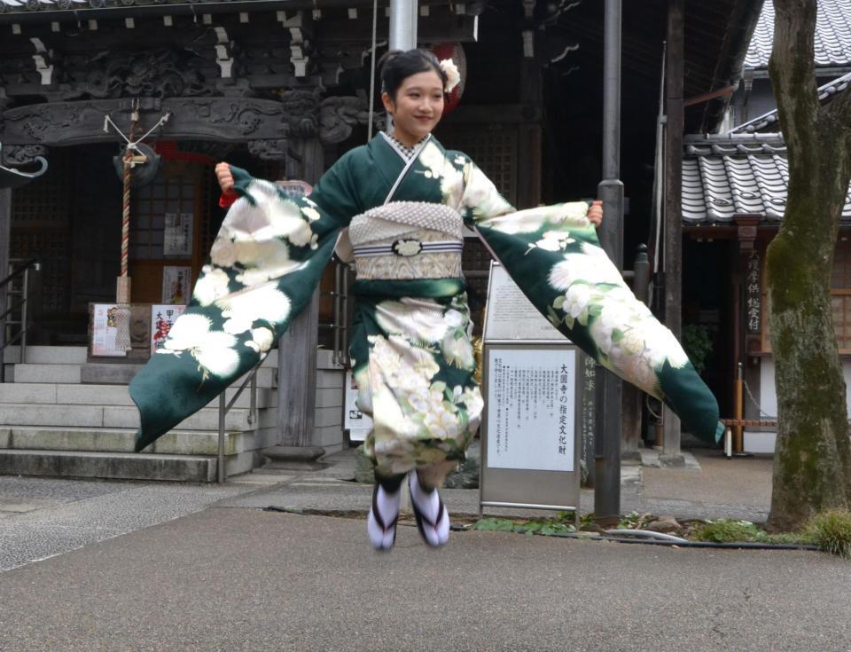 新成人となる１８歳を迎え、未来に向けてジャンプする山﨑玲奈＝目黒区・大圓寺