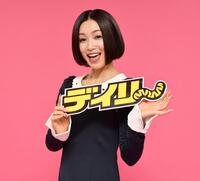 　デイリースポーツのロゴを手に笑顔の酒井法子（撮影・棚橋慶太）