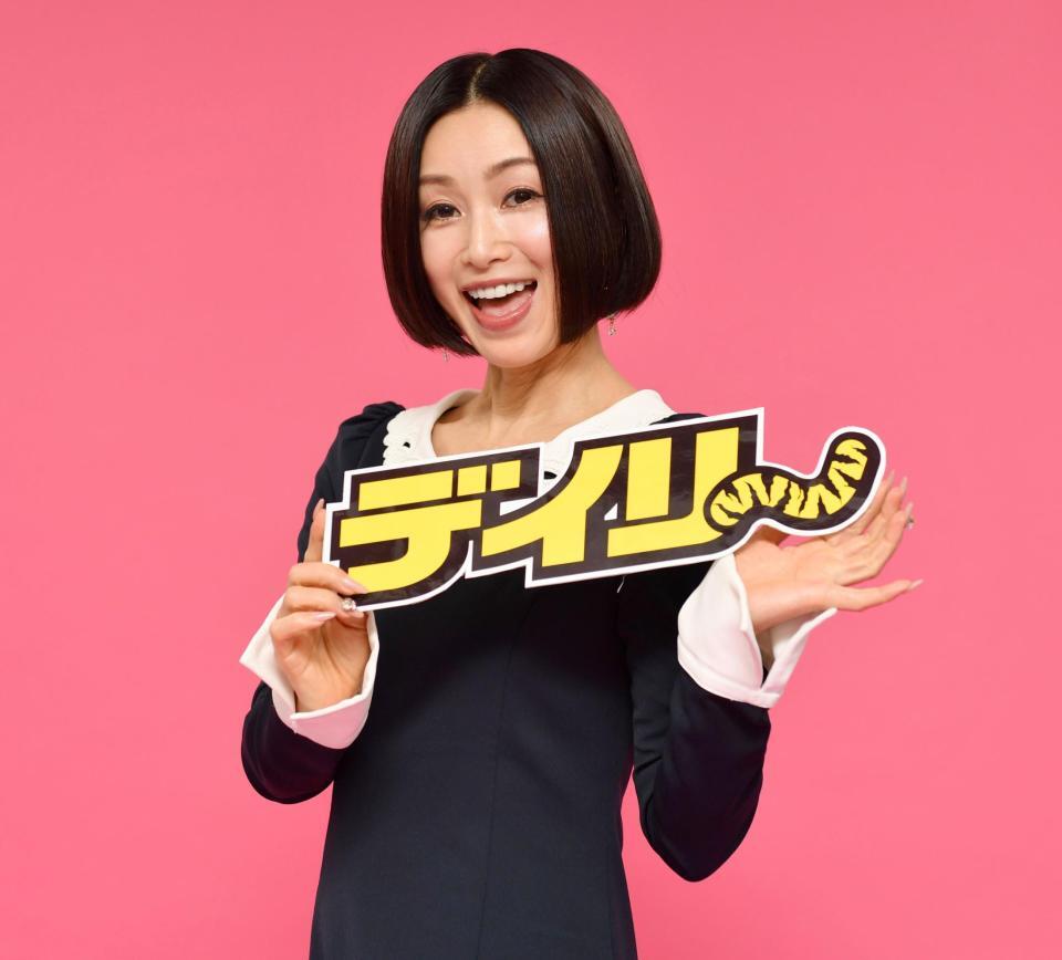 　デイリースポーツのロゴを手に笑顔の酒井法子（撮影・棚橋慶太）