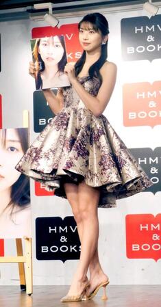 　写真集を手にする牧野真莉愛