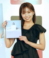 　写真集を手に笑顔の大原優乃