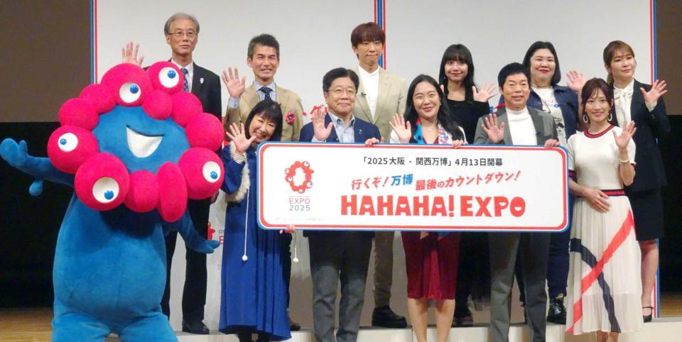 　登壇した（後列左３人目から）小山慶一郎、山之内すず、紅しょうが・熊元プロレス、稲田美紀、（前列左から）ハイヒール・リンゴ、加藤勝信財務大臣、１人置いて、今田耕司、亀井京子