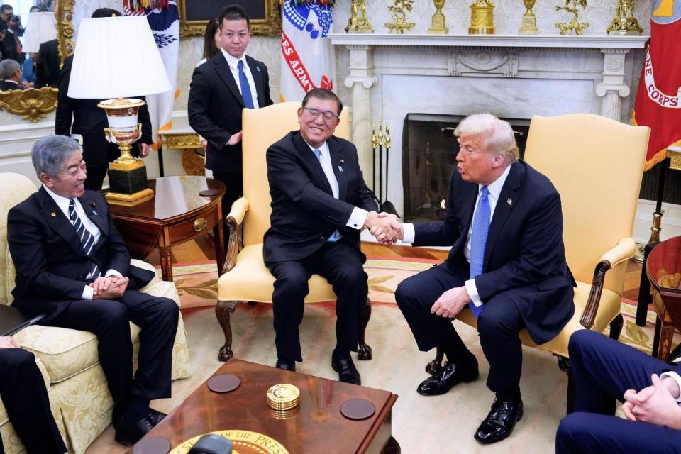 　首脳会談で握手を交わす石破首相（中央）とトランプ米大統領。左は岩屋外相（ロイター＝共同）