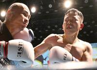 　若林元樹選手（左）に右フックを打ち込む宮迫博之