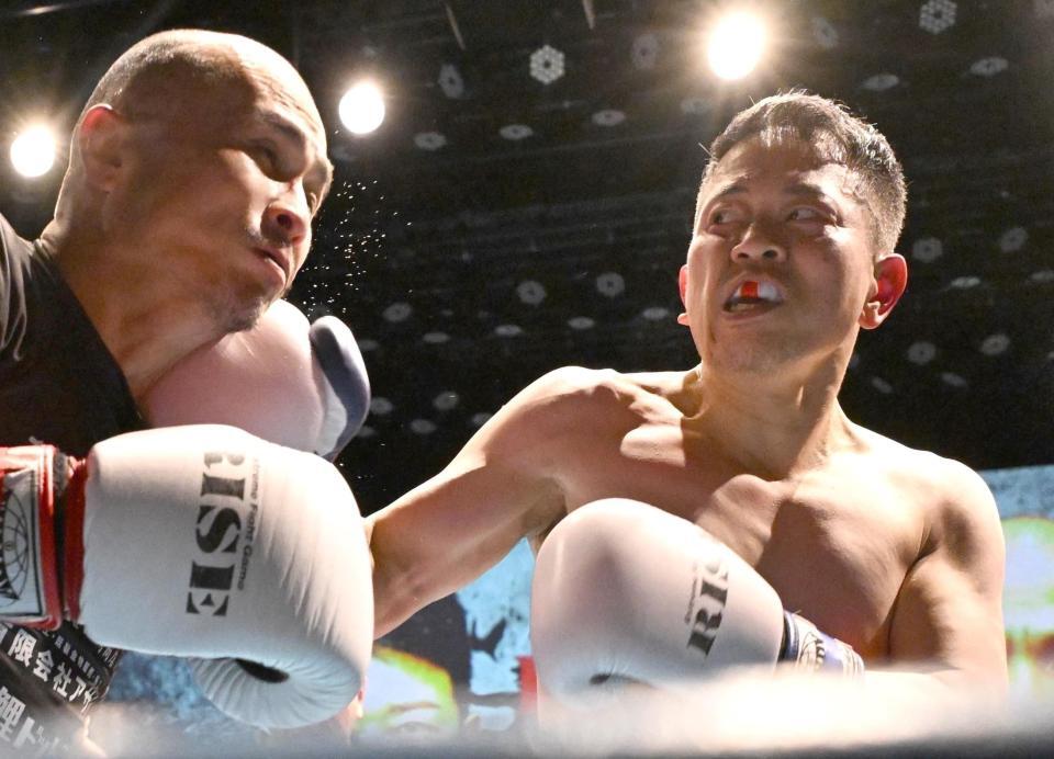 　若林元樹選手（左）に右フックを打ち込む宮迫博之