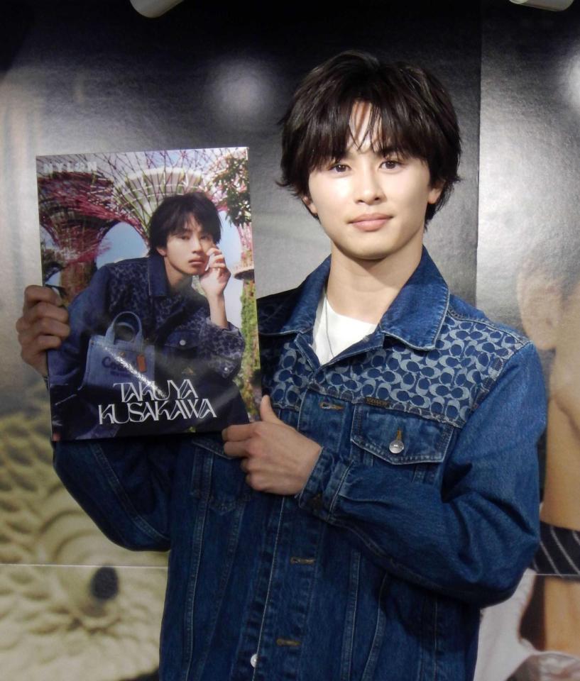 　本を手に撮影に応じる草川拓弥