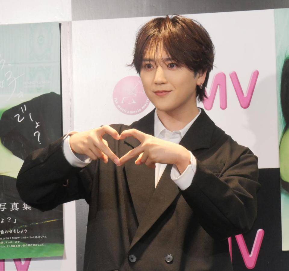 　指でハートを作って撮影に応じた草地稜之