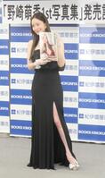 　美脚をあらわに写真集をアピールする野崎萌香