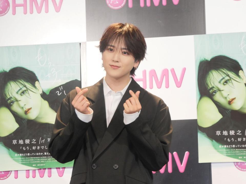 　指ハートをして撮影に応じた草地稜之