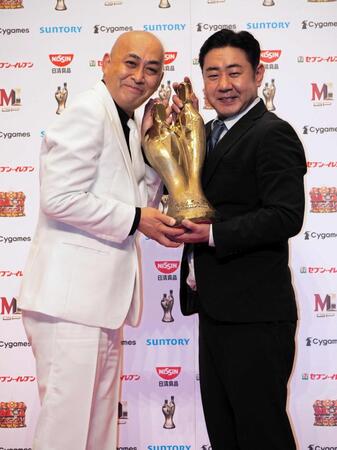 　トロフィーを持って喜ぶ錦鯉の長谷川雅紀（左）と渡辺隆＝２０２１年１２月