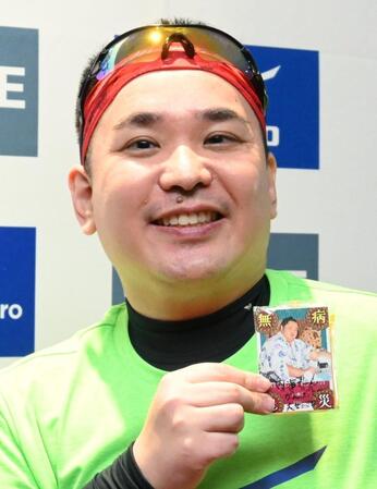 　沿道の子どもからプレゼントされたという大相撲カードを手に笑顔を見せるミルクボーイ・内海崇（撮影・高部洋祐）