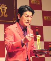 　イベントで実演調理した料理を試食し、笑顔の高橋克典