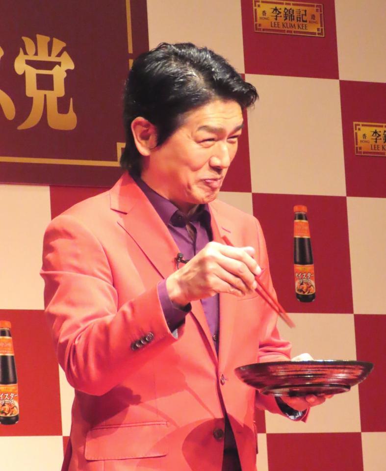 　イベントで実演調理した料理を試食し、笑顔の高橋克典