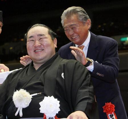 　朝青龍のまげにはさみを入れた後、笑顔で肩をたたく、みのもんたさん（右）＝１０年１０月３日