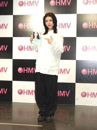 　出版本を手に笑顔を見せる井手上漠