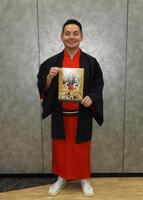 　自身主催フェスのチラシを手に笑顔を見せる錦笑亭満堂