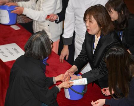 　募金活動に協力した来場者と握手を交わす林真理子氏（撮影・伊藤笙子）