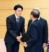 　石破首相（手前）と握手する佐々木＝首相官邸