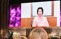 　最優秀助演女優賞に輝いた吉岡里帆（画面）と代理でトロフィーを受け取った藤井道人監督