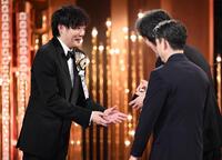 　最優秀監督賞を受賞し、役所広司（右奥）からトロフィーを受け取る藤井道人監督