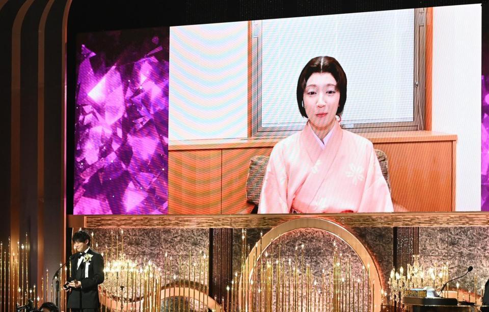 　最優秀助演女優賞に輝いた吉岡里帆（画面）と代理でトロフィーを受け取った藤井道人監督