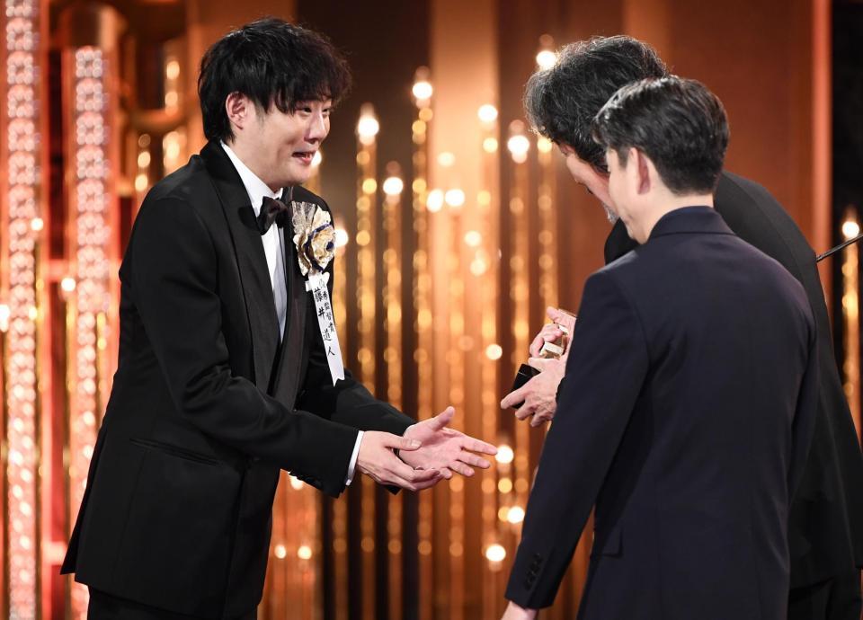 　最優秀監督賞を受賞し、役所広司（右奥）からトロフィーを受け取る藤井道人監督