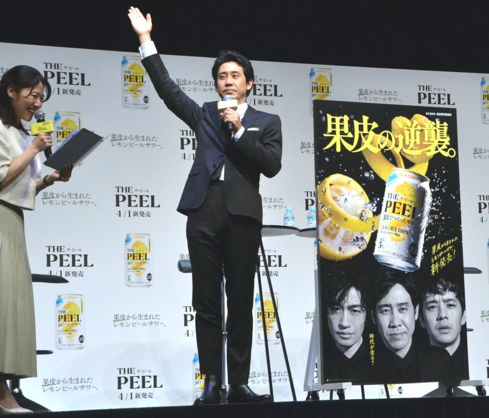 　新商品の看板を披露してポーズを決める大泉洋