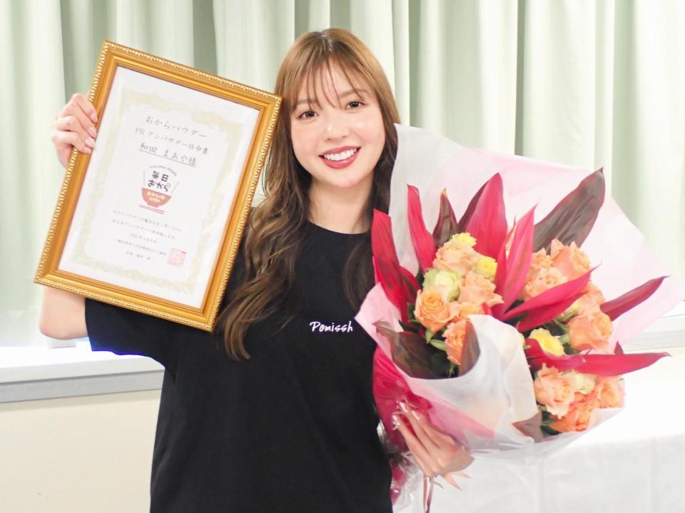 　おからパウダーＰＲアンバサダー任命書と誕生日祝いの花束を手に笑顔の和田まあや