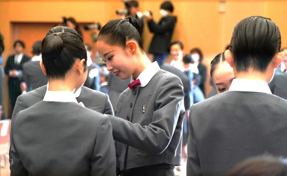 　本科生に校章を付けてもらう第１１３期生ら（撮影・高部洋祐）