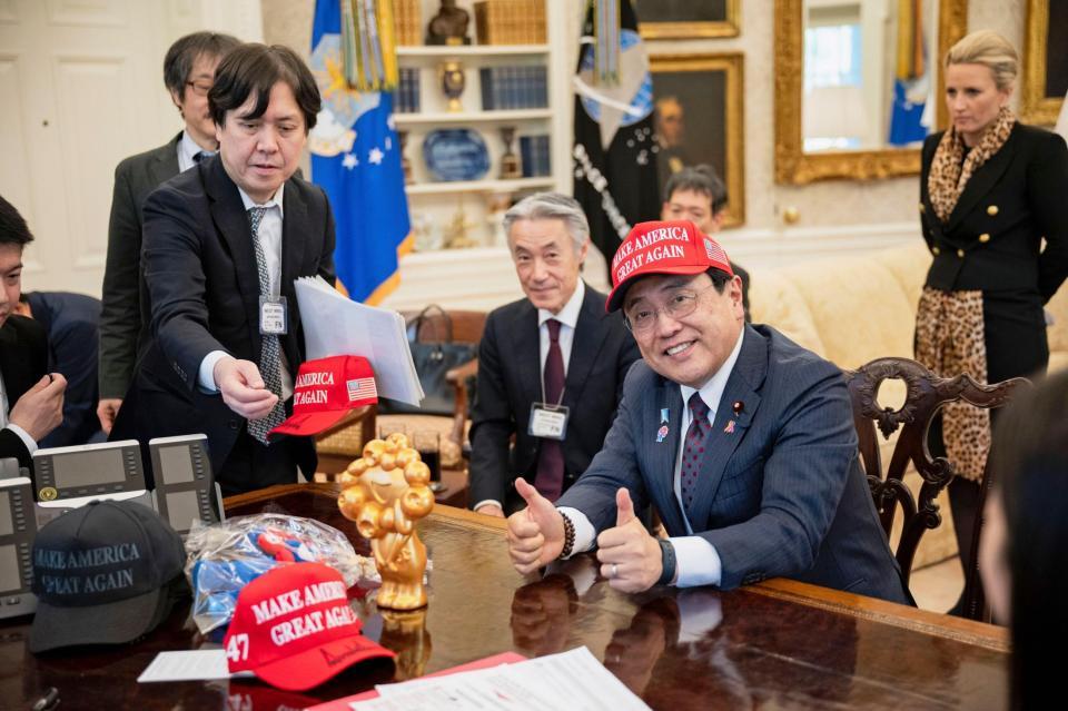 　ホワイトハウスで開かれたトランプ米大統領との会談でＭＡＧＡ帽子をかぶった赤沢経済再生相＝１６日（ホワイトハウス提供、共同）