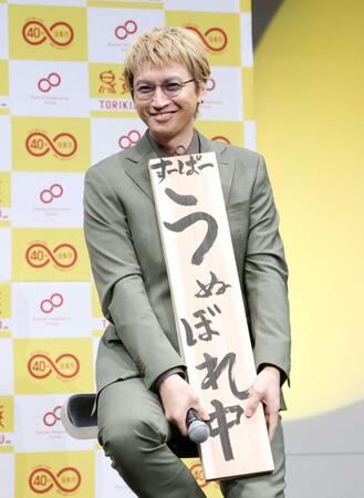 　直筆した看板を披露する大倉