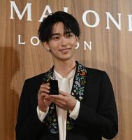 　商品を手にポーズにさわやかな笑顔の野村康太（撮影・開出牧）