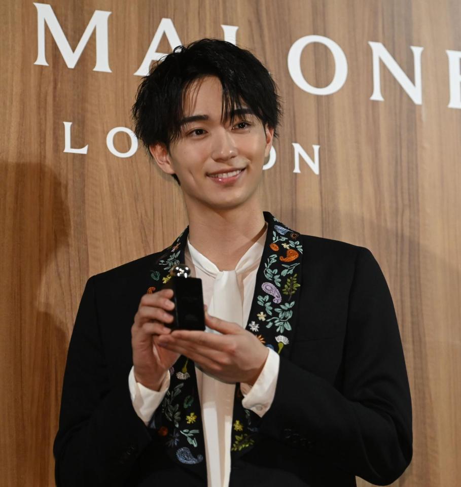 　商品を手にポーズにさわやかな笑顔の野村康太（撮影・開出牧）