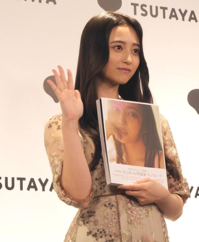 　写真集を手に笑顔を見せる井上和