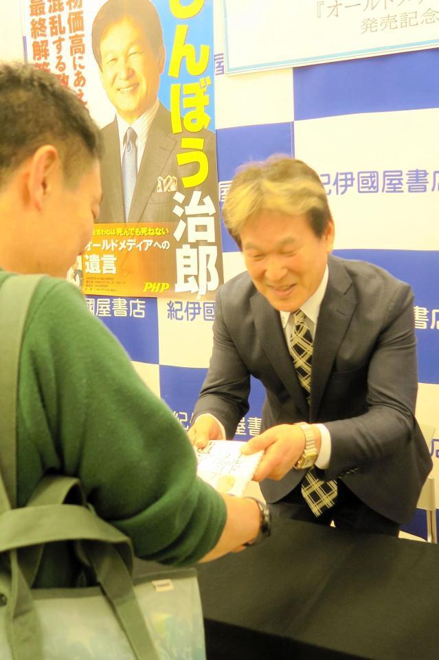 　著書にサインして渡す辛坊治郎氏