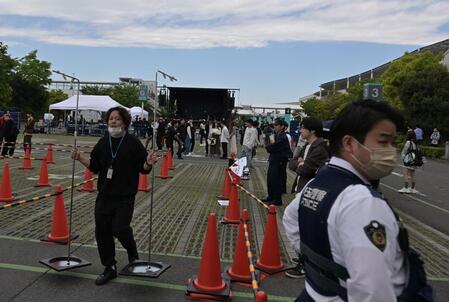 　≠ＭＥｉイベントが中止となりスタッフが撤収作業する所を警備する警察官（右）＝撮影・持木克友