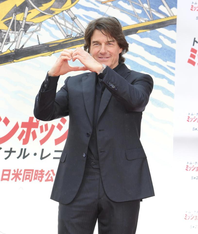 　ハートマークを作るトム・クルーズ（撮影・伊藤笙子）