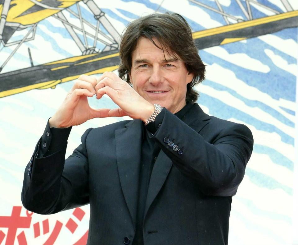 　ハートマークを作るトム・クルーズ（撮影・伊藤笙子）