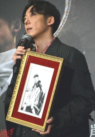 　荒木飛呂彦氏のイラストを手にする高橋一生