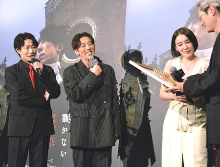 　荒木飛呂彦氏のイラストに見入る（左から）戸次重幸、高橋一生、飯豊まりえ、井浦新