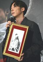 　荒木飛呂彦氏のイラストを手にする高橋一生